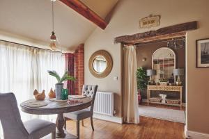 een woonkamer met een tafel en stoelen en een spiegel bij The Couple's Retreat in Ashbourne