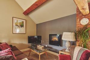 a living room with a couch and a tv at The Couple's Retreat in Ashbourne