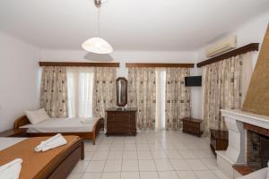 a living room with a bed and a fireplace at Hotel Villa Basil in Tsilivi