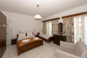 a hotel room with a bed and a couch at Hotel Villa Basil in Tsilivi