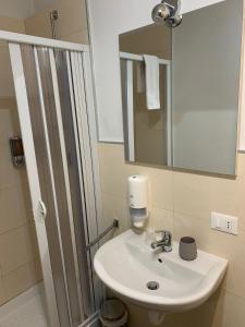 a bathroom with a white sink and a mirror at Residenza Lisy Rooms Affittacamere in Verbania