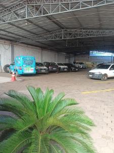 a blue van parked in a parking lot with cars at Borges Hotel in Imperatriz