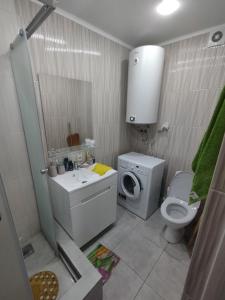 uma casa de banho com um WC, um lavatório e uma máquina de lavar roupa em Апартаменты рядом с морем em Sukhumi