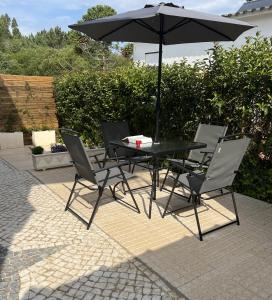 a black table and chairs with an umbrella at Farm stay in Maceira, Leiria 