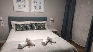 1 dormitorio con 1 cama con 2 pares de zapatillas en SUITEDREAMS - Avet 31, en Andorra la Vella