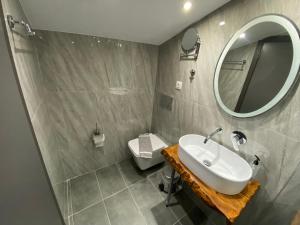 a bathroom with a sink and a mirror and a toilet at Hotel Almira in Agia Triada