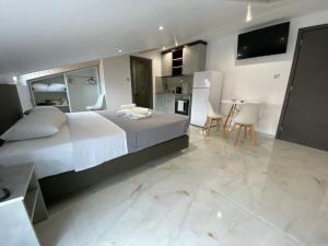 a bedroom with a large bed and a kitchen at Hotel Almira in Agia Triada