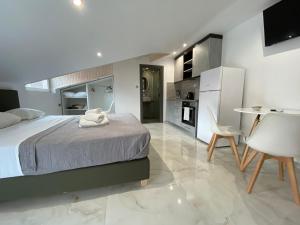 a bedroom with a bed and a table and a kitchen at Hotel Almira in Agia Triada