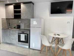 a kitchen with a refrigerator and a table with chairs at Hotel Almira in Agia Triada