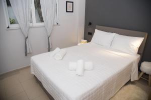 a bedroom with a white bed with two towels on it at Friends Luxury Apartment In Marousi in Athens