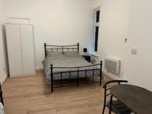 1 dormitorio con cama, mesa y ventana en Wembley Park Studios, en Londres