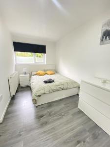 a white bedroom with a bed and a window at BEA Elcot Close in Manchester
