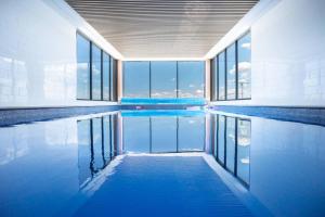 einen Pool mit blauem Wasser in einem Gebäude mit Fenstern in der Unterkunft Lux 2 Bed 2 Bath Apartment in the Heart of Dickson, Canberra in Canberra