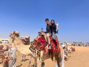 un grupo de personas montando en la espalda de un camello en king ramses pyramids view apartment en El Cairo