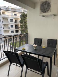 a black table and chairs on a balcony at Apartment Trebinje Sun in Trebinje