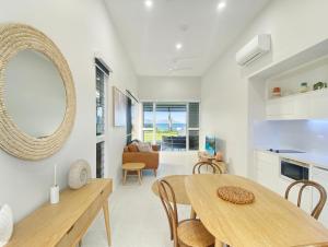 a kitchen and dining room with a table and a mirror at Rock Salt Villa 2 in Picnic Bay