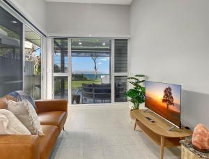 a living room with a couch and a flat screen tv at Rock Salt Villa 2 in Picnic Bay