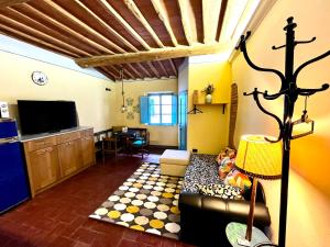 a living room with a couch and a tv at Turquoise Rose Apartment in Peccioli