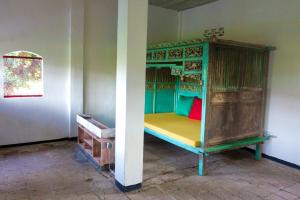 um quarto com uma cama verde e um colchão amarelo em Gubuk Kurnia em Sawan