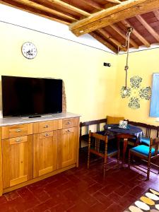 sala de estar con TV de pantalla plana y mesa en Turquoise Rose Apartment, en Peccioli
