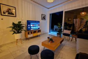 a living room with a television and a table and chairs at AOG PRESTIGE logement neuf avec SPA et écran de cinéma en rez de jardin in Colmar