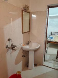 a bathroom with a sink and a mirror at Royal Guest House in Bharatpur