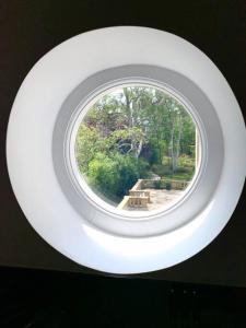 a round window in a room with a park in the background at Scholar's Loft - Cosy & Close to Central Cambridge in Cambridge