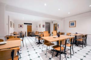 a dining room with wooden tables and chairs at KC Inn Hotel in London