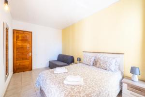a bedroom with a bed and a chair at Entire Apartment 5min from Oura Beach in Albufeira