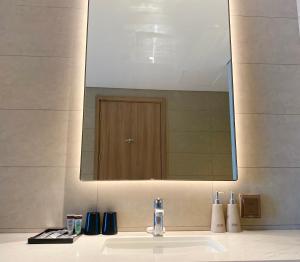 um lavatório de casa de banho com um grande espelho por cima em Căn hộ Alacarte Hạ Long view Biển, bãi tắm, bể bơi ngay trung tâm Bãi Cháy em Ha Long