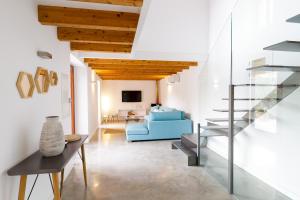 a living room with a staircase and a blue couch at Can Tortet in Pollença