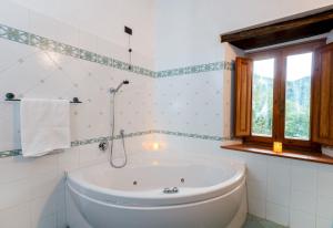 a bathroom with a tub and a window at Casa Al Colle in San Romano +16 photos