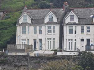 two white houses on the side of a hill at Looe Spacious 4 Double bedroom House Sleeps 9 Harbour River Views in Looe