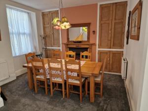a dining room with a wooden table and chairs at Looe Spacious 4 Double bedroom House Sleeps 9 Harbour River Views in Looe