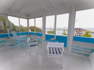 a porch with two chairs and a table on it at Denizkizi butik otel in Küçükkuyu