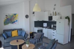 ein Wohnzimmer mit einem Sofa und einer Küche in der Unterkunft Summer House Krištof in Vrbanj