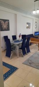 uma sala de jantar com uma mesa e cadeiras azuis em Dimora Village em Alexandria