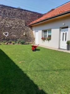 a yard with a red bench in front of a building at Villa Monica in Kráľovský Chlmec