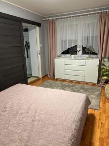 a bedroom with a bed and a dresser at Villa Monica in Kráľovský Chlmec