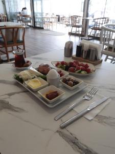 una mesa con platos de comida en una mesa en Denizkizi butik otel en Kucukkuyu