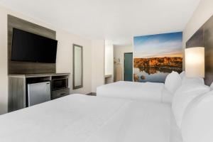 Habitación de hotel con 2 camas y TV de pantalla plana. en Clarion Pointe Prescott Valley en Prescott Valley