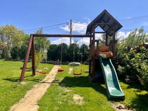 un parque infantil con un tobogán y un osito de peluche. en Casa Cenţiu en Bran