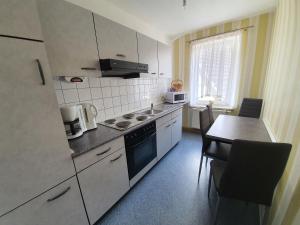a kitchen with a table and a stove top oven at Ferienwohnung am See in Regis-Breitingen