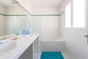 ein weißes Badezimmer mit einer Badewanne, einem Waschbecken und einer Badewanne in der Unterkunft Bassin Arcachon, Mais. 3 étoiles, spa, 500 m plage in Gujan-Mestras