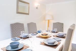 a dining room table with plates and glasses on it at Central 2 Bed House w/ Garden and Free Parking! in Cheltenham