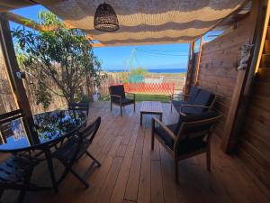 a patio with a table and chairs on a deck at La Case Savane in Saint-Leu