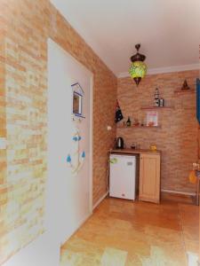 a kitchen with brick walls and a white refrigerator at Denizkizi butik otel in Küçükkuyu