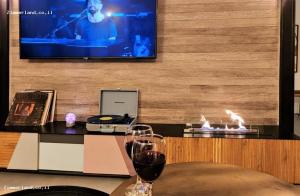 una copa de vino sentada en una mesa frente a una TV en Casa Nov Complex, en Nov