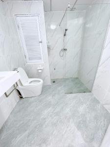 a white bathroom with a shower and a toilet at Sea sand sun Condominiums in Rayong
