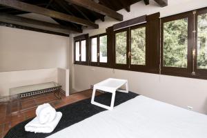 Habitación con cama, banco y ventanas en Navitour Santa Ana, en Granada